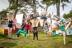 Circus Artists gather together in varying poses beneath the entrance arc to Caravanserai