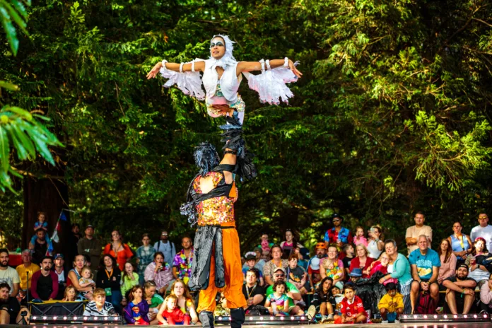 The Silent Forest show being performed at Camp Bestival Shropshire - performers dressed as birds dance and perform amongst the trees to a mesmerised crowd