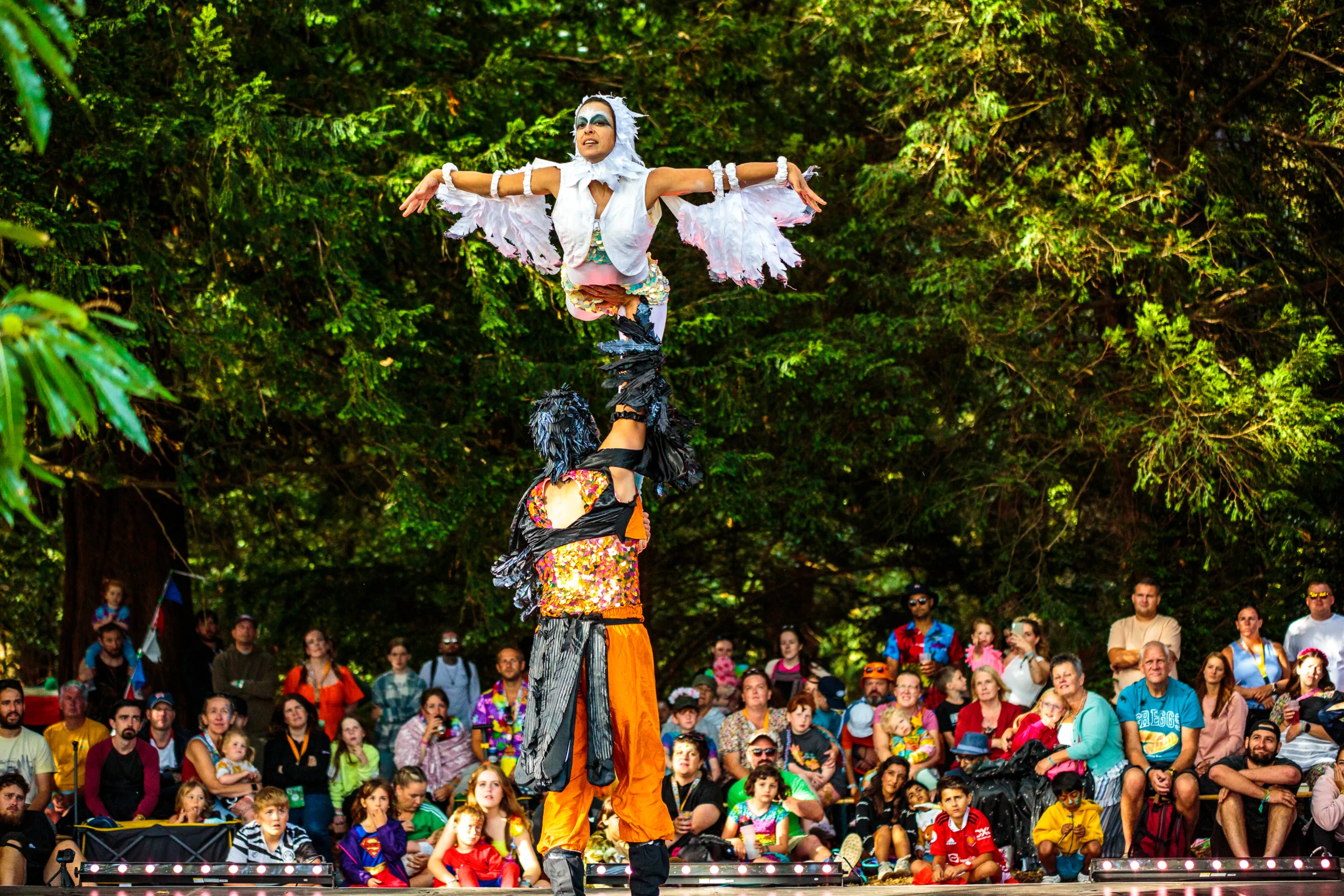 The Silent Forest show being performed at Camp Bestival Shropshire - performers dressed as birds dance and perform amongst the trees to a mesmerised crowd