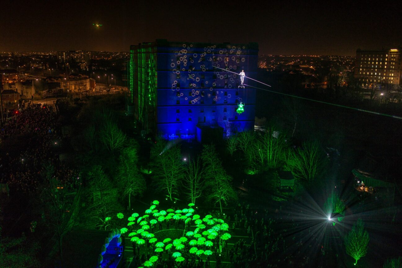 A faraway shot of the city, with our green umbrellas forming a circle on the ground