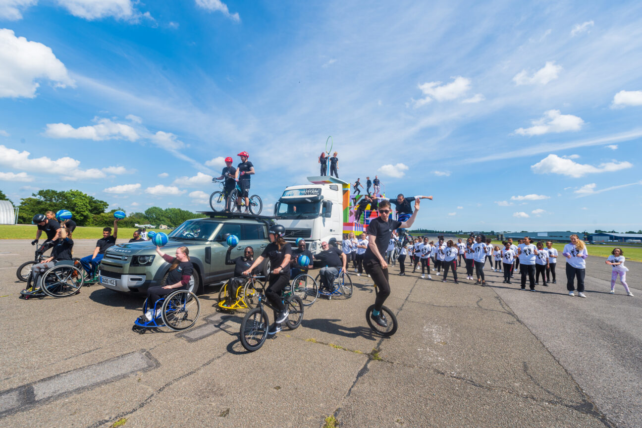 An outside rehearsal shot of our float for the jubilee pageant. Lots of performers are caught mid-performance - dancing, unicycling, riding...