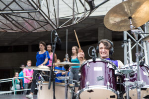 Extraordinary Bodies performer Jonny Leitch plays drums in What Am I Worth? National Theatre River Stage. Image Rob Harris. 