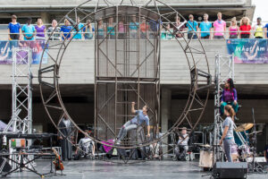 Extraordinary Bodies performer Amelia Cavallo lays in steal structure in What Am I Worth? National Theatre River Stage. Image Rob Harris.