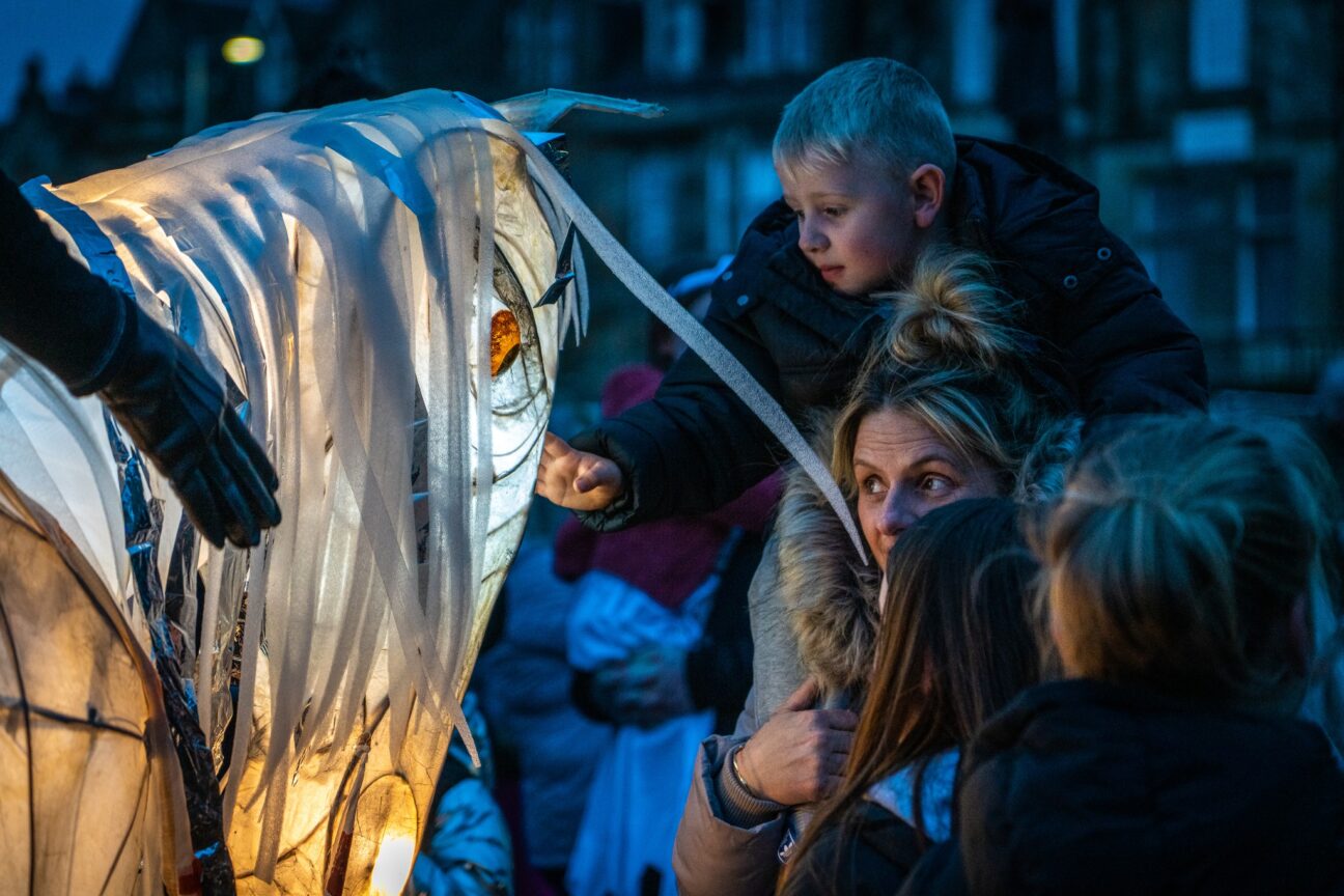 A close up of audience interaction with one of our illuminated puppets at Paisley Halloween Festival