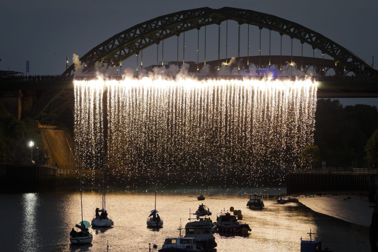 Tall Ships Race Sunderland, Cultural Festival. Sunderland July 2018. From a bridge in the centre of the image there is a pyrotechnic waterfall above the boats below on the water.