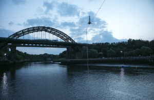 Performer Chris Bulzini does a handstand on the wire over the River Weir. Portolan, Sunderland Tall Ships, Cirque Bijou. Image Dan Prince. 