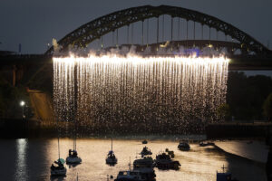 A pyrotechnic waterfall cascades from the River Weir Bridge. Portolan, Sunderland Tall Ships, Cirque Bijou. Image Mark Pinder.