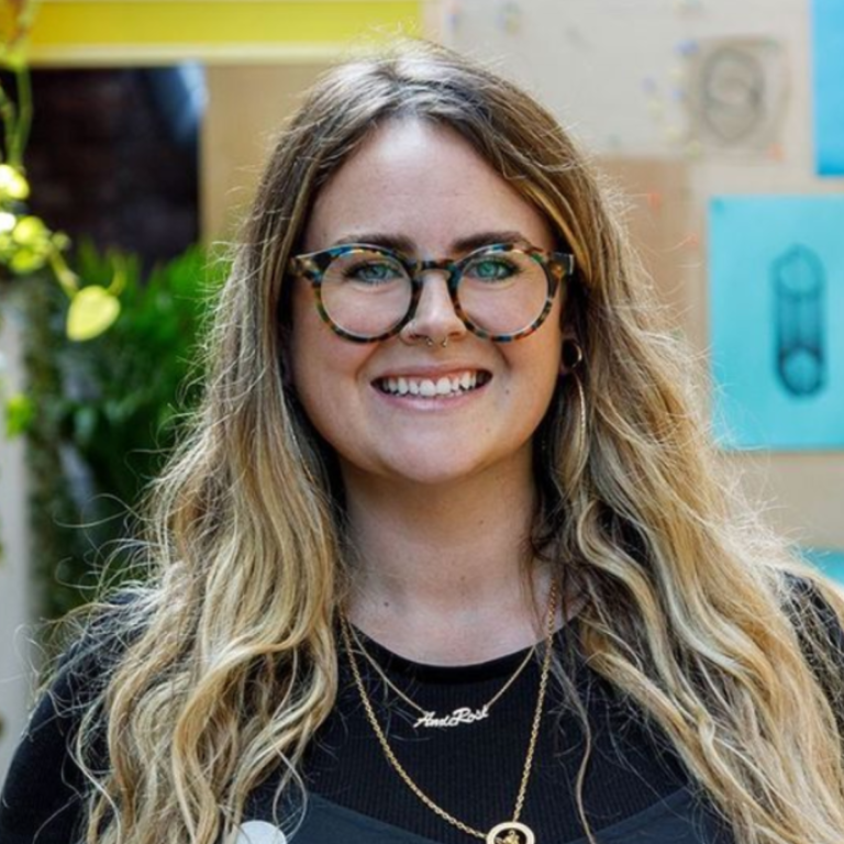 Amie Thompson, freelance bookkeeper, smiling at the camera wearing glasses.