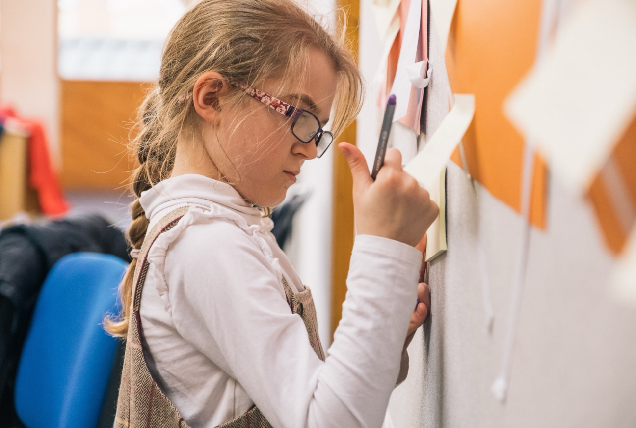 A young girl making notes at the Kitchen Circus Project.