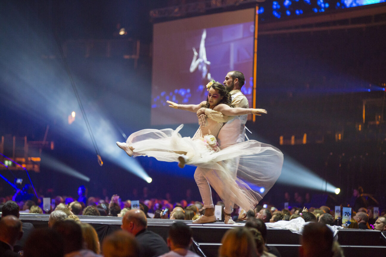 Two dancers perform on stage amongst the audience