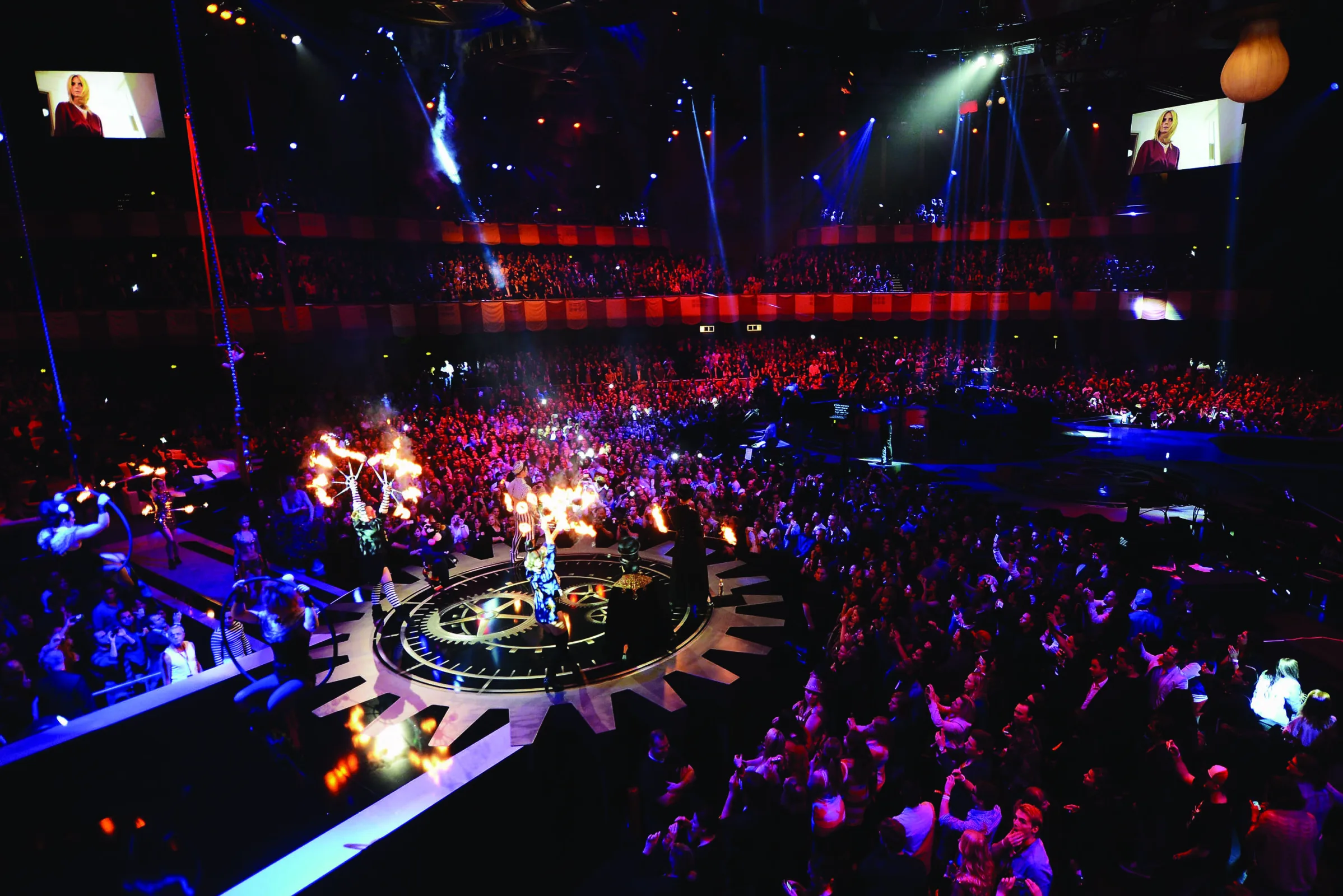 A large stadium filled with audience keenly watching a performer on stage