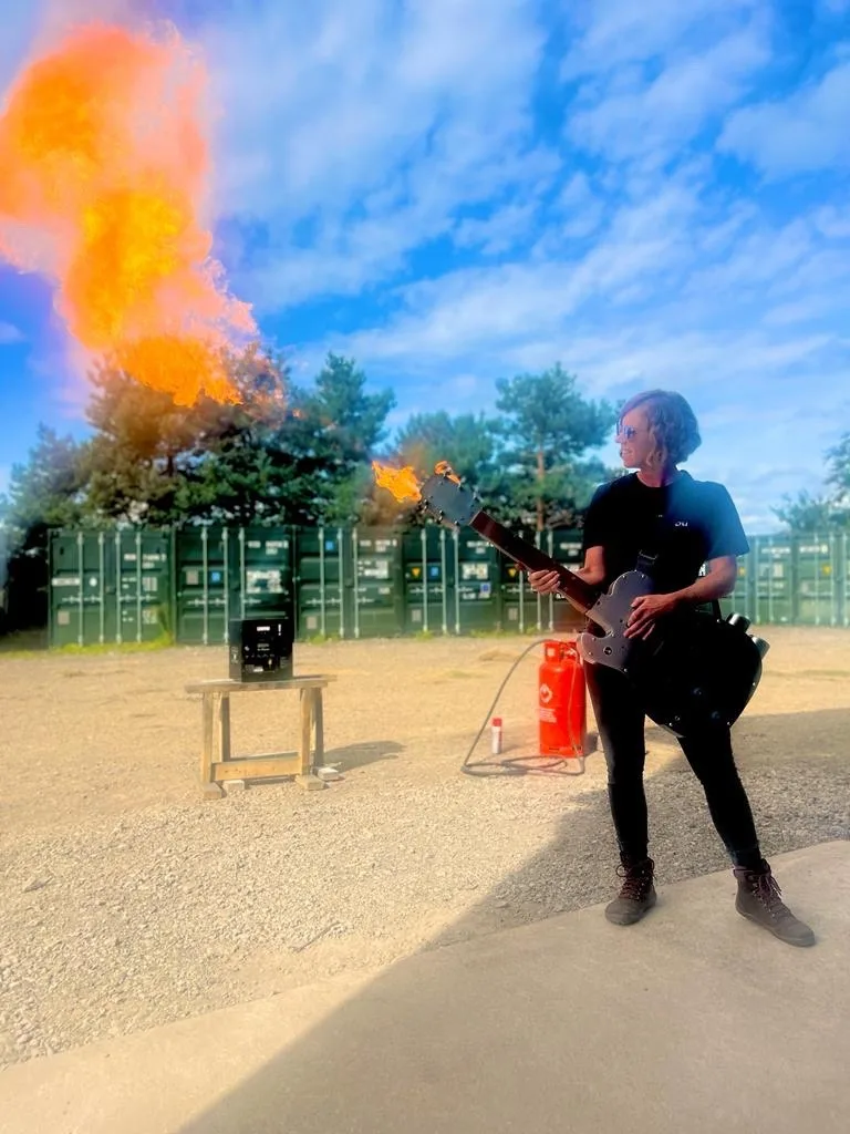 Geraldine holds a flaming guitar